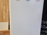 a white refrigerator with stickers on it in a room
