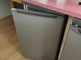 a pink counter top with two refrigerators and a fan on it