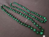 a close up of a green beaded necklace on a table