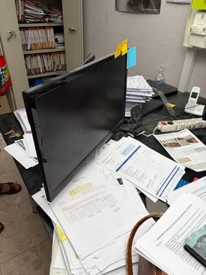 a laptop computer sitting on top of a cluttered desk