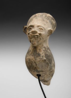 un gros plan sur une statue représentant une tête posée sur un socle