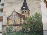 a painting of a church on a table next to a pair of boots