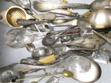 a lot of silver spoons and spoons that are on the table