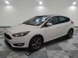 La Ford Focus blanche est garée dans une pièce dont le sol est en damier.