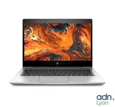 un ordinateur portable ouvert posé sur une surface blanche