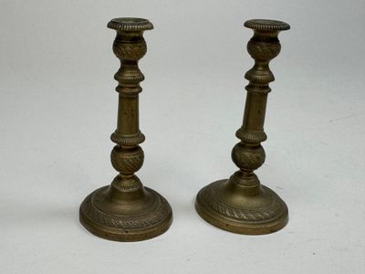 pair of antique brass candlesticks on a white background