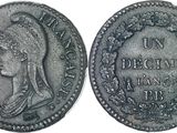 a silver coin with a woman ' s head and a wreath on it