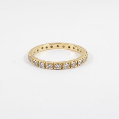 a yellow gold ring with white diamonds on a white background