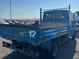 a blue truck that is parked in a lot