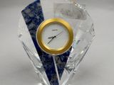 une horloge bleue et blanche posée sur un bloc de cristal