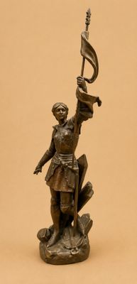 bronze statue of a man holding a flag and a sword