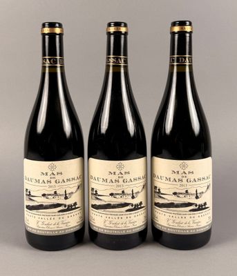 trois bouteilles de vin posées sur une table l'une à côté de l'autre
