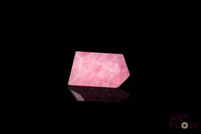 a pink quartz stone sitting on top of a black surface