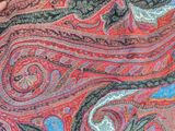 a woman that is holding a large colorful shawl