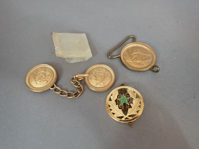 two gold cuff watches and a gold keychain with a cross on it