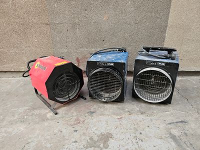trois radiateurs portatifs posés les uns à côté des autres par terre