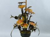 un vase contenant des fleurs, posé sur une table où se trouve une lampe