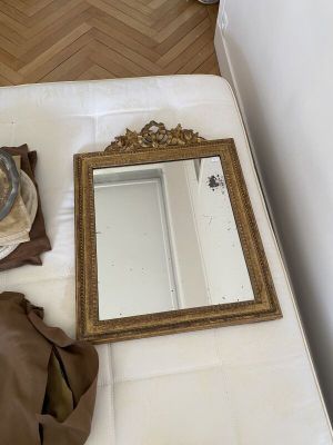 un lit sur lequel sont posés un miroir et un chapeau
