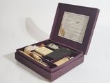 purple box containing a variety of items including a cigarette, a lighter, and a cigarette case