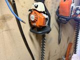 une photo d'une tronçonneuse et d'autres outils accrochés au mur