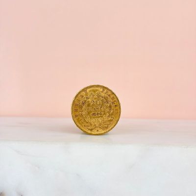 a gold coin sitting on top of a marble slab