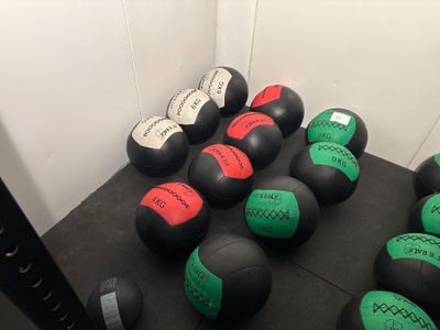 de nombreux ballons médicinaux posés par terre dans une pièce