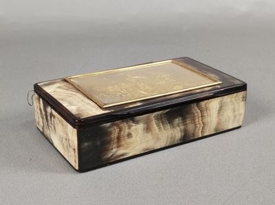 une petite boîte posée sur une table, sur laquelle se trouve un livre