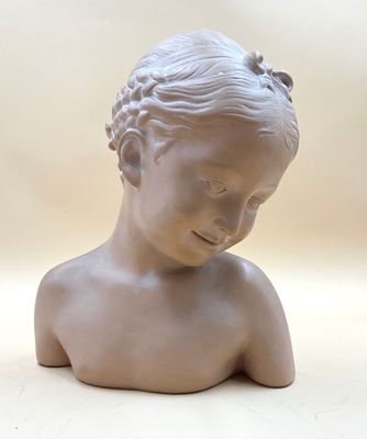 a small statue of a young boy with a flower in his hair