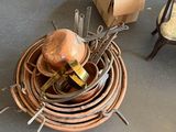 a pile of copper pots and pans sitting on the floor