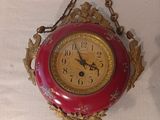 une horloge rouge et dorée accrochée au mur