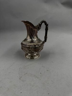 un pichet ancien en métal argenté sur fond blanc