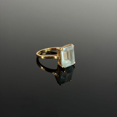 Gros plan sur une bague en or ornée d'une topaze bleue