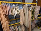 beaucoup de vêtements suspendus à une étagère dans une pièce