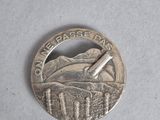 a silver coin with a picture of a plane on it