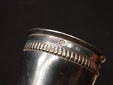 a silver cup that is sitting on top of a table