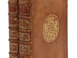 un vieux livre orné d'un emblème doré sur la couverture