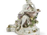 une figurine représentant une femme assise sur un rocher