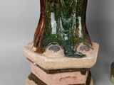 pair of green and brown vases sitting on top of a table