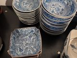 many blue and white plates and bowls on the table