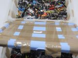un bac en plastique rempli de Lego de toutes sortes posé sur une table