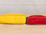 two red and yellow bags sitting on top of a wooden table