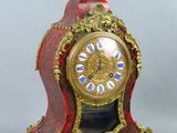 une horloge rouge et dorée posée sur une table