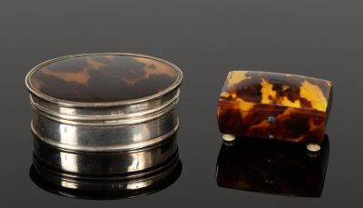 une carapace de tortue et un coffret en argent posés sur un fond noir