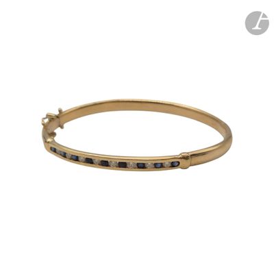 un pendentif en or jaune orné de pierres bleues et de diamants