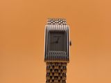 une montre posée sur un socle, sur un fond marron
