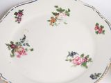 two plates with flowers on them on a white table