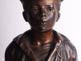 bronze statue of a boy in a sailor ' s outfit with a hat on