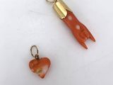 deux bijoux en corail et en or sur une surface blanche