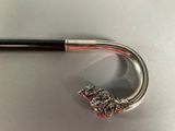 a silver and black umbrella with a red handle