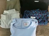 quatre paires de chemises et de pantalons pour homme étalées par terre